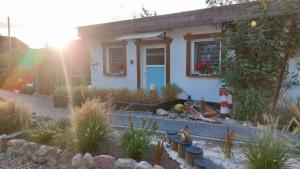 une maison avec une porte bleue et quelques plantes dans l'établissement Dat Strandhus up'n Dörp, à Zirkow