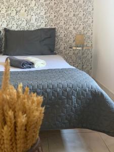 a bed with a gray comforter in a bedroom at Skopelos Inn in Stafylos