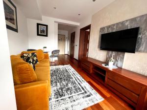 a living room with a couch and a flat screen tv at VIP Apartamenty Stara Polana in Zakopane