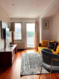 a living room with a yellow couch and a tv at VIP Apartamenty Stara Polana in Zakopane