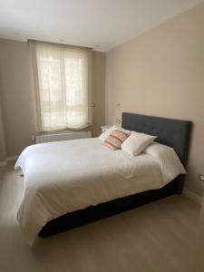 a bedroom with a large white bed with a window at Apartamento Moderno Centro Bilbao in Bilbao