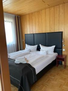 ジーゲンにあるHotel Schäferの大型ベッド1台(黒いヘッドボード付)が備わる客室です。