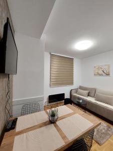 un soggiorno con divano e tavolo di Apartman Loly Zlatibor a Zlatibor