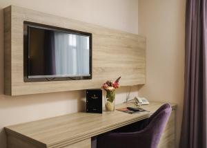 Zimmer mit einem Schreibtisch und einem TV an der Wand in der Unterkunft Hotel Stella Maris - Style & Comfort in Vodice