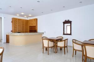 a dining room with tables and chairs and a counter at Niros Beachfront Aparthotel in Kokkíni Khánion