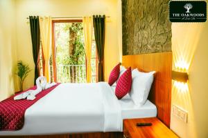 1 dormitorio con 1 cama con almohadas rojas y blancas en The Oakwoods, en Bhowāli