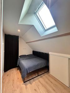 Un dormitorio con una cama y una claraboya. en La pause bretonne, en Quimperlé