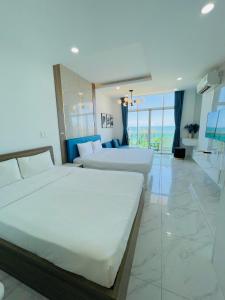 Habitación de hotel con 2 camas y ventana grande. en Sealiks Ocean vita Codotel muine C326, en Phan Thiet