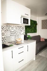 uma cozinha branca com um sofá na sala de estar em Le Cosy - Centre Ville - 2 pièces em Beauvais