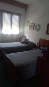 een hotelkamer met 2 bedden en een raam bij Sea Horse in Lido di Camaiore