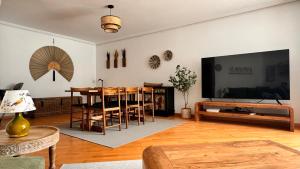 a living room with a dining table and a television at Exclusive Lerma - Smart TV de 75", Netflix y Parking Gratis in Lerma