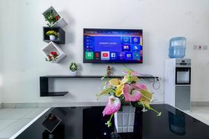 モンバサにあるBstan Homes 3 Bedroom Mombasa With ACの花の壁にテレビが付いた部屋