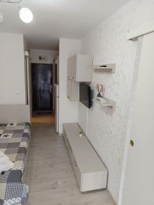 Cette petite chambre comprend un lit et un mur blanc. dans l'établissement Dika Sofia Residence, à Mangalia
