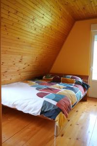a bed in a room with a wooden ceiling at Vila Zeleno borje in Žabljak