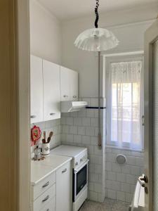 a kitchen with white cabinets and a white stove top oven at Chez Dodo Ospedaletti in Ospedaletti +13 photos