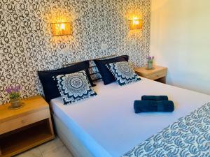 a bedroom with a white bed with blue pillows at Skopelos Inn in Stafylos