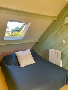 a bedroom with a blue bed with a window at Maison de vacances 5 voyageurs in Cherbourg en Cotentin