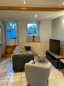 a living room with a couch and a tv at Maison de vacances 5 voyageurs in Cherbourg en Cotentin +31 photos