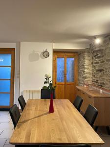 a dining room table with chairs and a vase with flowers at Maison de vacances 5 voyageurs in Cherbourg en Cotentin