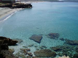 a body of water with rocks and the ocean at B&B Neverland in Marrùbiu