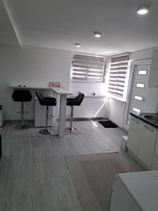 a kitchen with a table and stools in a room at Apartman Avlija in Tuzla