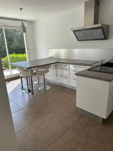 Una cocina con una mesa y algunas sillas. en Appartement de prestige avec piscine, en Laouque