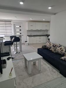 a living room with a couch and a table at Apartman Avlija in Tuzla