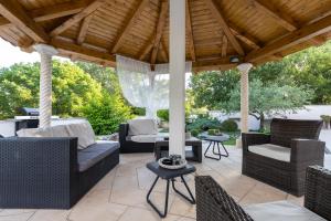 a patio with wicker furniture under a wooden roof at Holiday Home Rajna in Pražnice