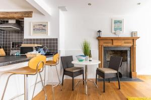 a kitchen with a table and chairs and a fireplace at Duke House ground floor Apartment in Padstow