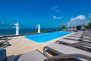a swimming pool with lounge chairs next to the ocean at Simus Beach Hotel in Side