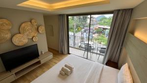 a room with a bed and a television and a window at Rocco Apartments a Cosy Luxury Stay Holiday Home in Krabi in Ao Nang Beach +23 photos