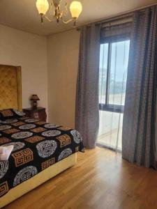 サレにあるSuperbe appartement Marina Rabatのベッドと大きな窓のある寝室