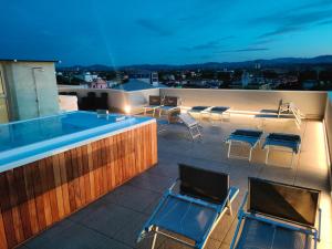 a patio with chairs and a swimming pool on a roof at Wally Residence in Rimini