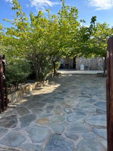 un cortile in pietra con alberi e un edificio di Guesthouse Kamara II a Monemvasía