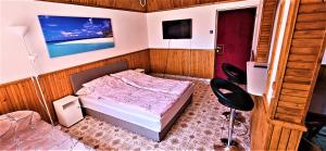 a small bedroom with a bed and two chairs at Alex's Hajdúszoboszló in Hajdúszoboszló