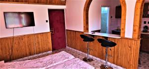 a room with a bar and two stools in a kitchen at Alex's Hajdúszoboszló in Hajdúszoboszló