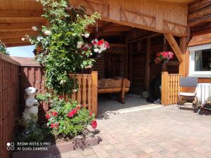 eine Veranda eines Holzhauses mit Blumen darauf in der Unterkunft FeWo Am alten Holzplatz in Drübeck