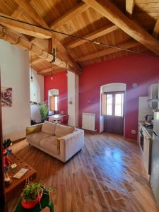 ein Wohnzimmer mit einem Sofa und einer roten Wand in der Unterkunft Civico16 Appartamento in LʼAquila