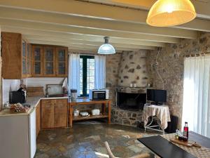 a kitchen with wooden cabinets and a stone wall at Guesthouse Kamara II in Monemvasia