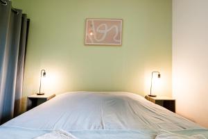 une chambre avec un lit avec deux lampes dessus dans l'établissement Appartement cosy 5 mins Honfleur piscine terrasse, à Équemauville 34 autres photos