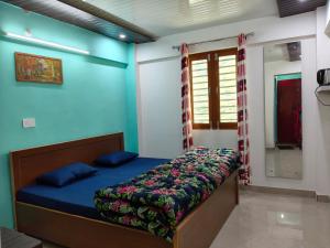 a bedroom with a bed with a blue wall at Him-Kim Homestays in Badrinath