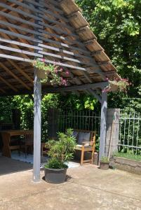 a wooden pergola with potted plants on a patio at Стаи за гости "Maroli House 2" 