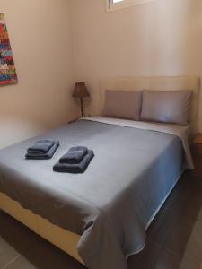 a bedroom with a large bed with two towels on it at Smile Stay Apartment in Alexandroupoli