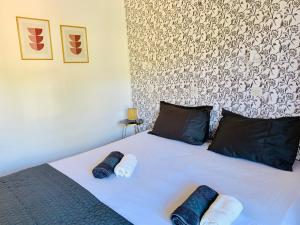 a bed with two blue and white towels on it at Skopelos Inn in Stafylos