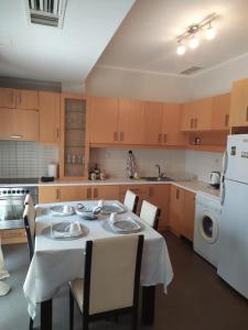 a kitchen with a table with chairs and a white appliance at Smile Stay Apartment in Alexandroupoli +8 photos