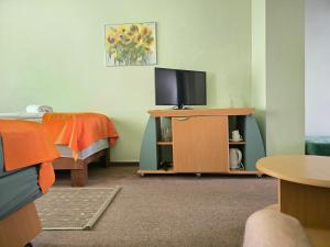 a room with a tv on a table with a bed at Hotel Promenade in Palanga +36 photos