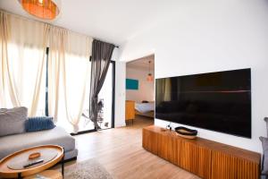 a living room with a large flat screen tv at Book Jet - Casilla de Costa Dreams in Villaverde