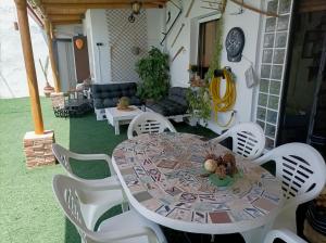a table and white chairs in a living room at Casa Jienense in Campillo del Río
