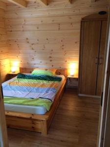 a bedroom with a bed in a wooden wall at Ferienhaus Ronja in Hemfurth-Edersee