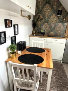 cocina con mesa de madera y sillas blancas en Deluxe Apartment, en Duisburg